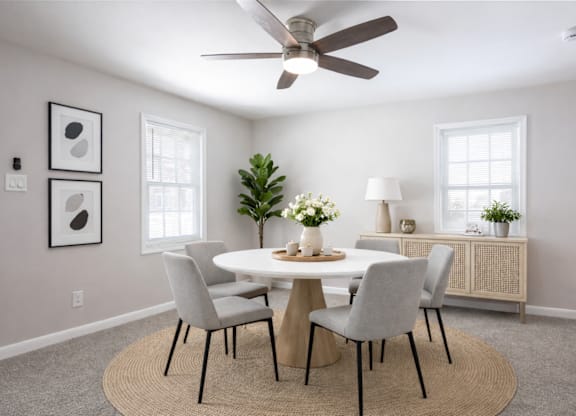 A dining room with a round table and chairs.