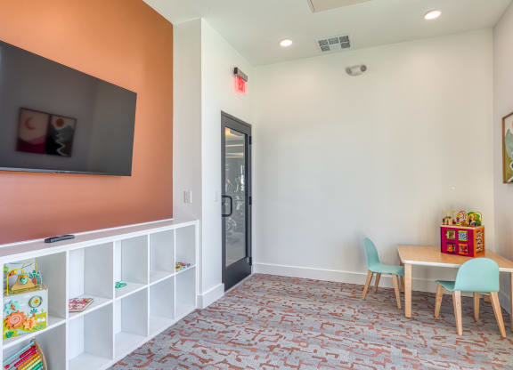 a play room with a table and chairs and a television