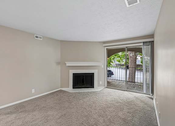 A living room with a fireplace and sliding glass doors.