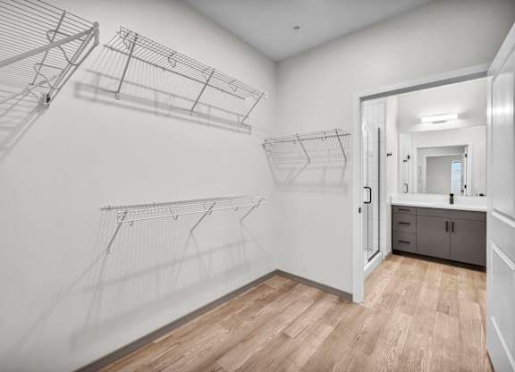 A white laundry room with a wooden floor and a white door.