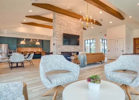 a living room with chairs and a table and a fireplace at Allure at Edinburgh, Virginia