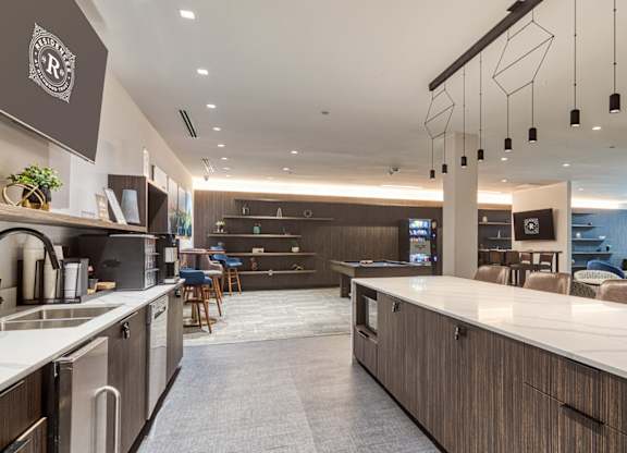 A modern kitchen with a long white counter and brown cabinets at Residences at Richmond Trust in Richmond, 23219