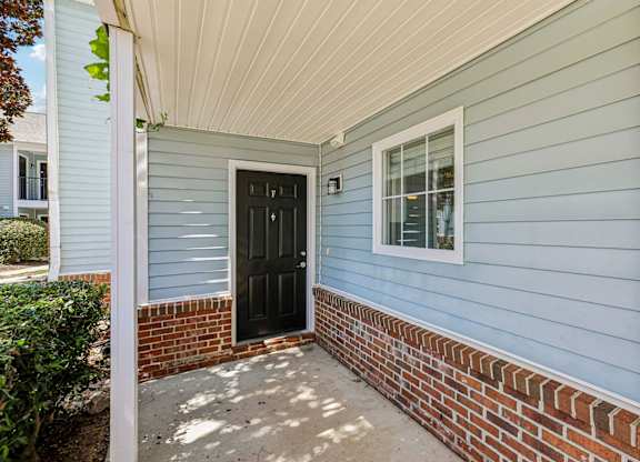 A blue house with a black door and a window.
