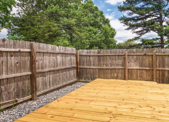 a backyard with a wooden deck and a wooden fence