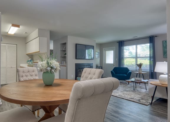 a living room and dining room with a table and chairs