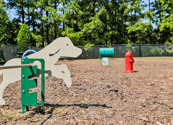A dog sign is in front of a fence and a red fire hydrant.