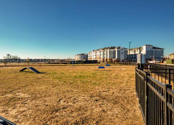 A playground with a swing set and a fence in the foreground.