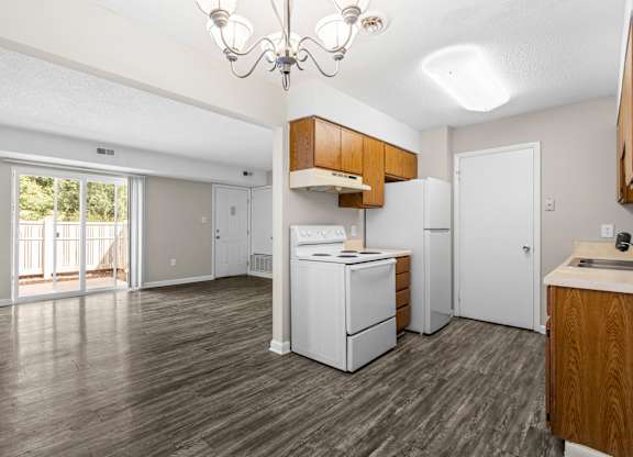 A kitchen with white appliances and wooden cabinets.