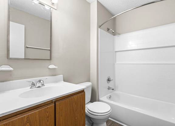 A white bathroom with a toilet, sink, and bathtub.