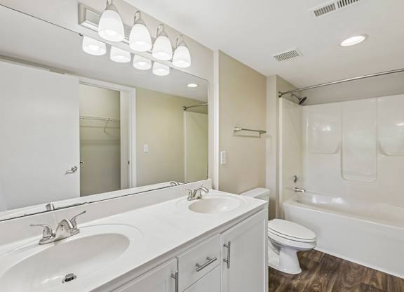 A white bathroom with a sink, toilet, and bathtub.