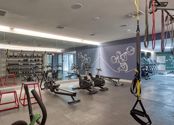 A gym with exercise equipment and a wall mural at Residences at Richmond Trust in VA, 23219