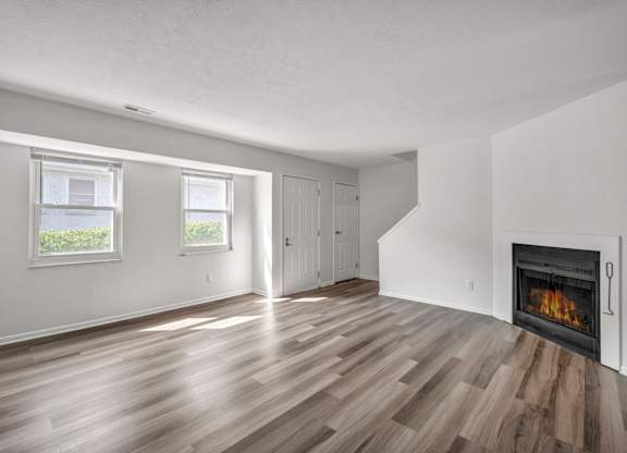 A room with a fireplace and wood flooring.