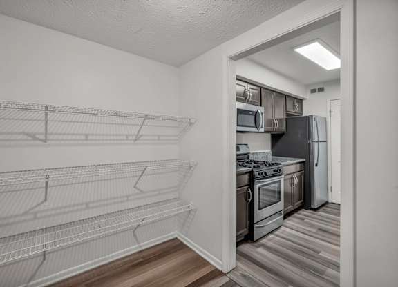 A kitchen with a refrigerator, oven, and microwave.