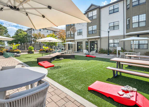 A patio area with tables and chairs and umbrellas.