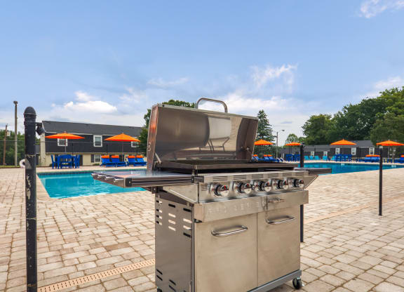 a stainless steel grill next to a swimming pool