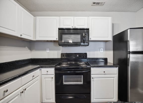 a kitchen with black appliances and white cabinets