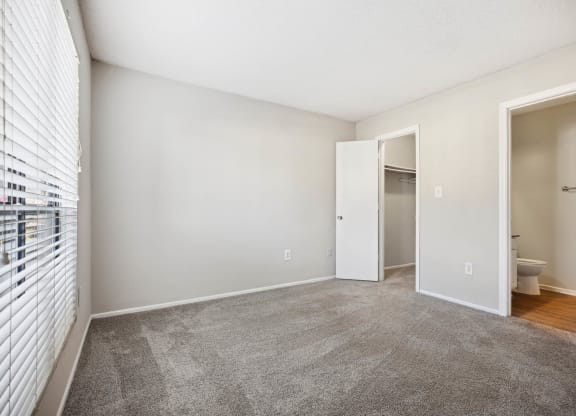 a living room with carpet and a door to a bathroom