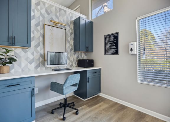 a home office with a desk and a chair and a window
