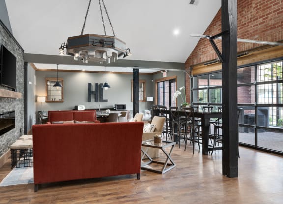 a living room with a red couch and a table with chairs and a fireplace at Hayden Lofts, Dublin, OH