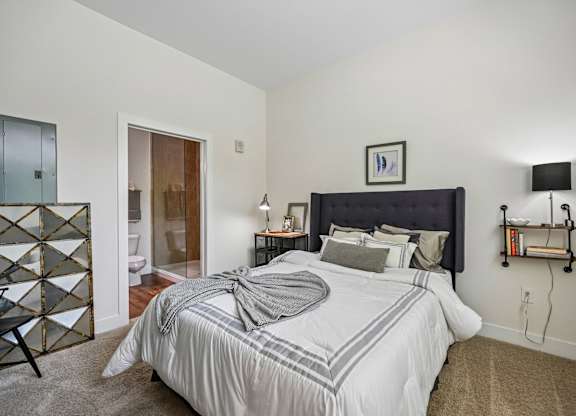 A bedroom with a large bed and a black headboard.