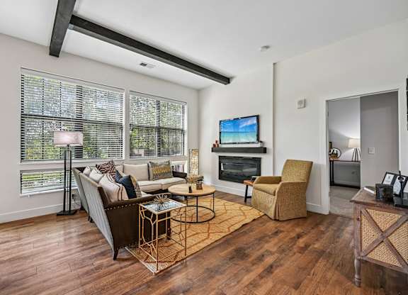 A living room with a couch, chair, and television.