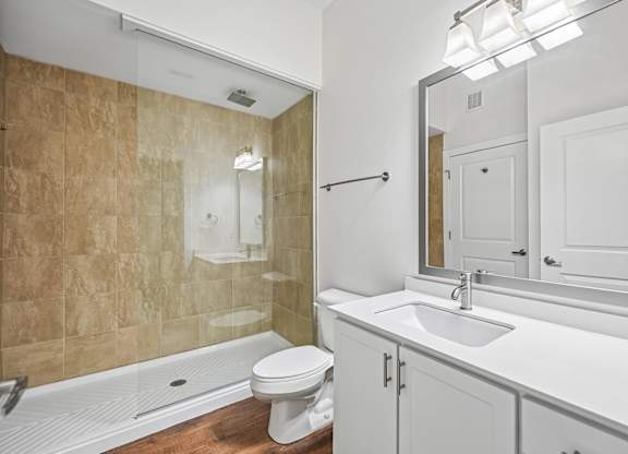 A bathroom with a toilet, sink, and shower.