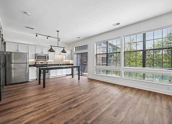 A kitchen with a wooden floor and a table with chairs.