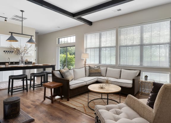 a living room with couches and chairs and a kitchen with windows at Hayden Lofts, Dublin, OH, 43016