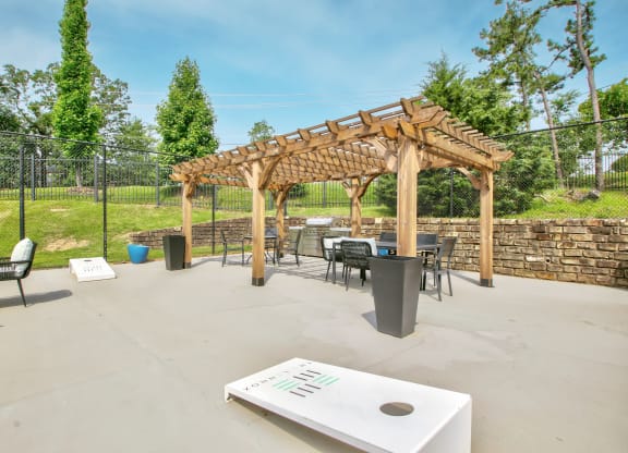 a patio with tables and chairs and a wooden pavilion
