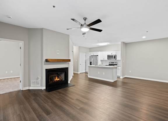 A modern living room with a fireplace and a ceiling fan.