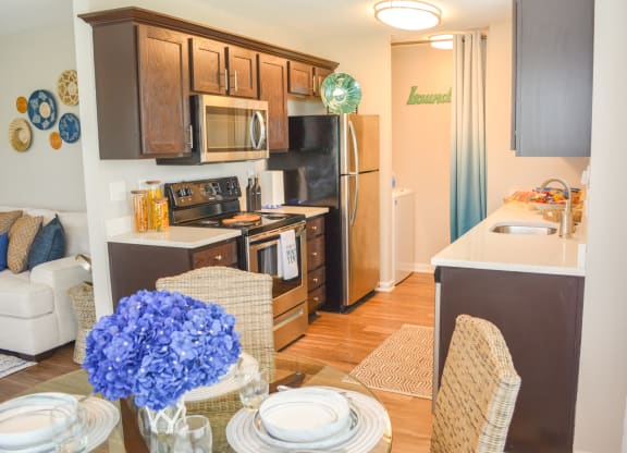 a kitchen with stainless steel appliances and wooden cabinets and a dining table