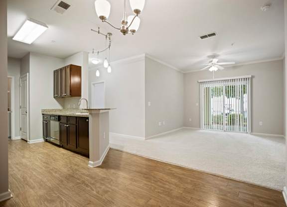 A kitchen with a white ceiling and a window with blinds.