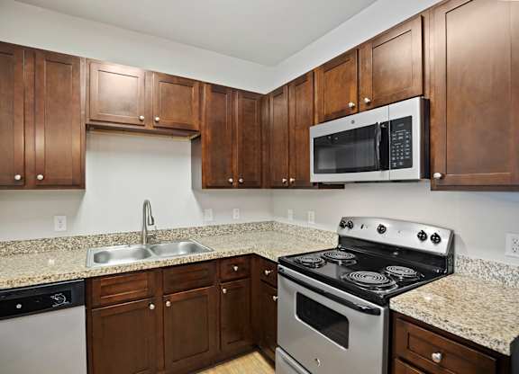 A kitchen with brown cabinets and a black stove top oven.