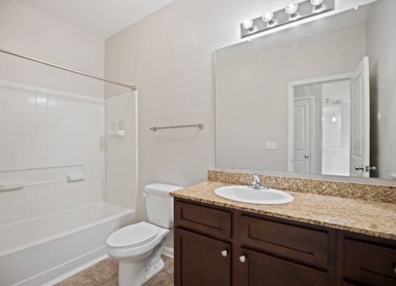 A white toilet sits next to a sink in a bathroom.