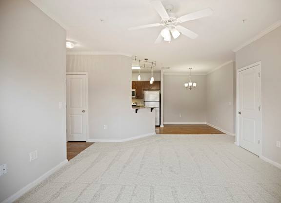 A room with a ceiling fan and a rug on the floor.