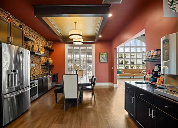 A kitchen with a table and chairs in the middle of the room.