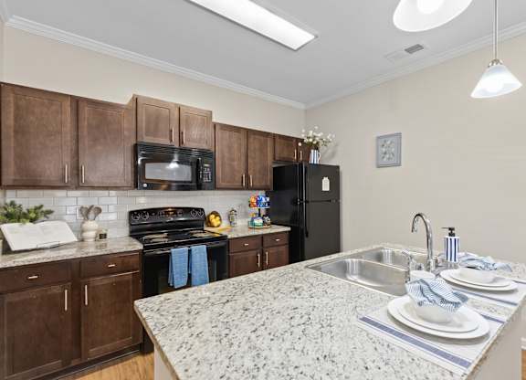 A kitchen with granite countertops and wooden cabinets.