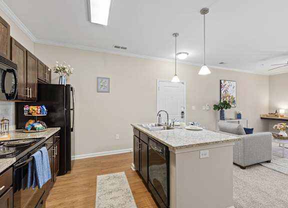 A kitchen with a black refrigerator and a marble countertop.