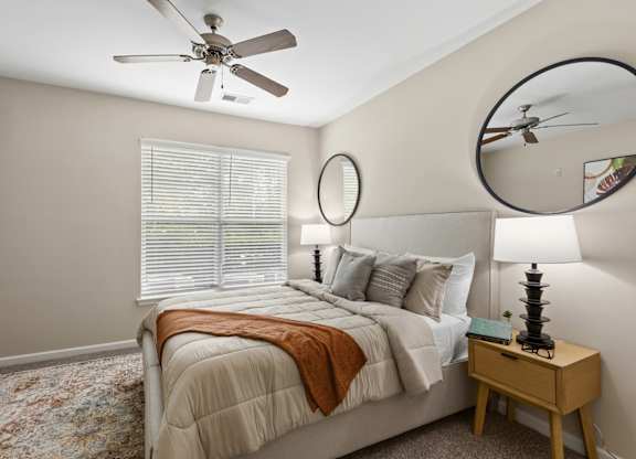 A bedroom with a large bed and a ceiling fan.