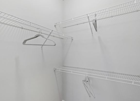 A white wire shelf with a hanger on it.