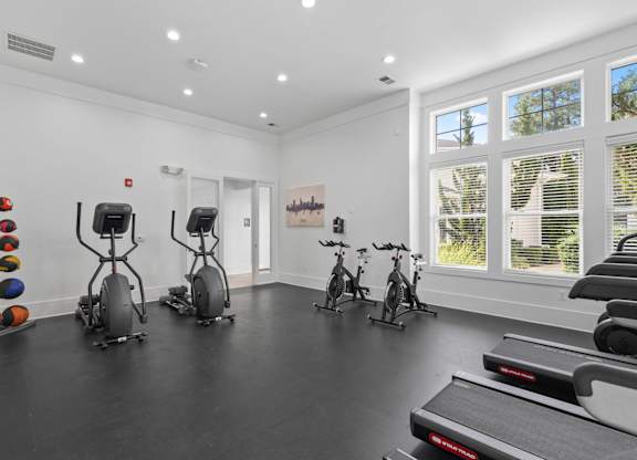 A room with exercise equipment and windows.