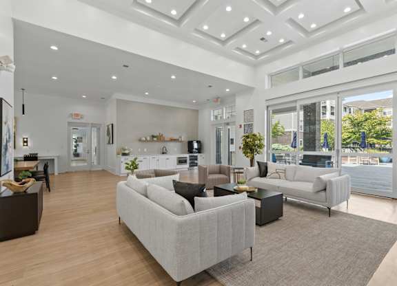 A spacious living room with a grey sofa and a wooden floor.