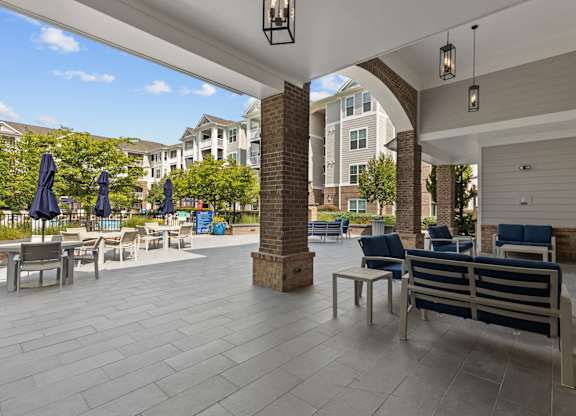 A patio with a table and chairs and umbrellas.