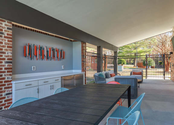 A patio with a table and chairs is surrounded by a brick wall.
