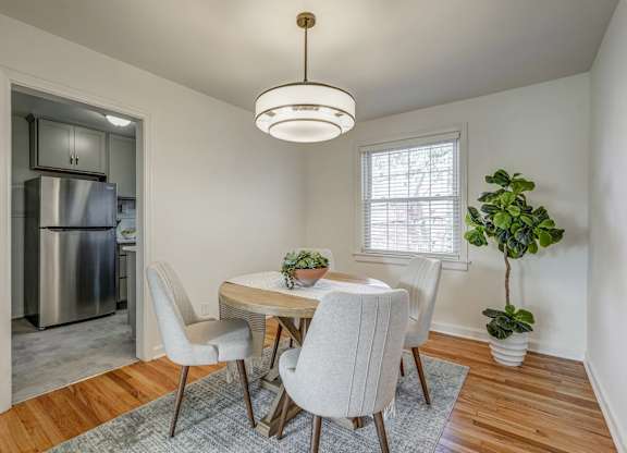 A dining room with a table and chairs.