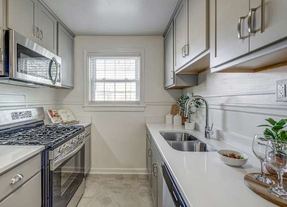 A kitchen with a stove, microwave, and sink.
