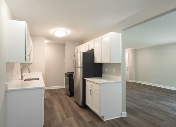 a kitchen with white cabinetry and a black refrigerator