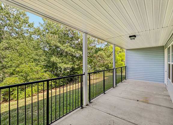 A balcony with a black railing and a white ceiling.