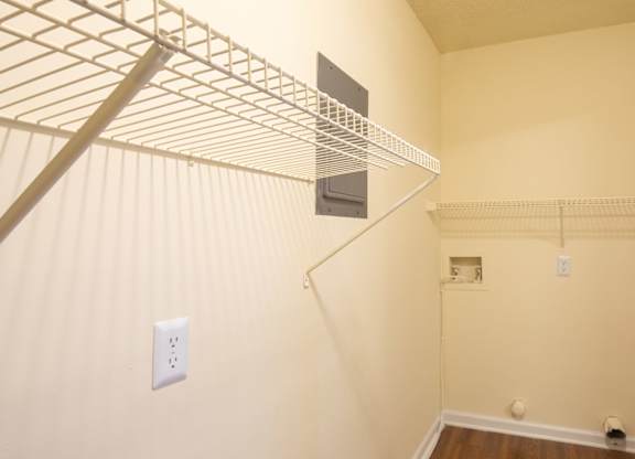 A white wall with a shelf and a light switch.