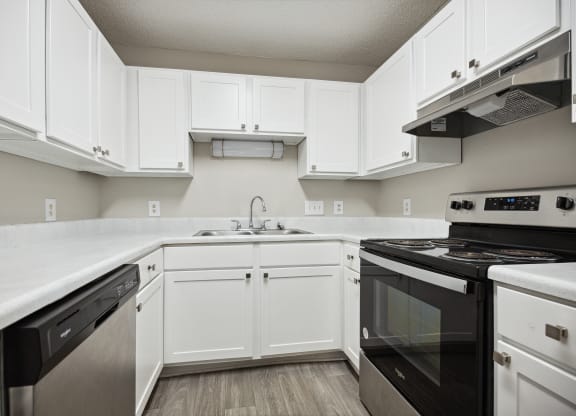 a kitchen with white cabinets and black appliances